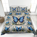 Blue butterfly quilt blanket with floral panels styled on a bright bedroom bed