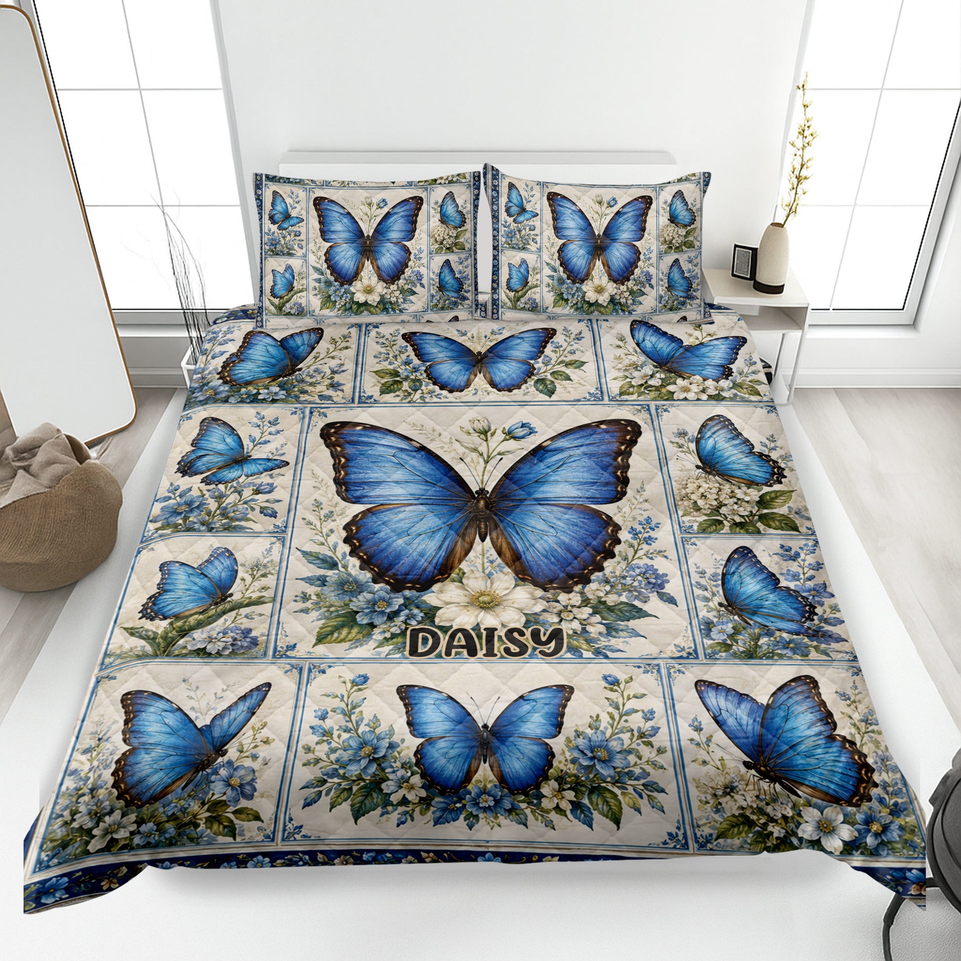 Blue butterfly quilt blanket with floral panels styled on a bright bedroom bed