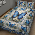 Close bedroom view of a blue butterfly quilt blanket with botanical floral artwork