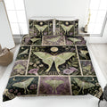Butterfly quilt blanket with moonlit botanical panels and pale green wings displayed on a bedroom bed