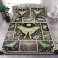 Moonlit butterfly quilt blanket styled on a bright bedroom bed with floral botanical artwork