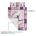 Gymnastics quilt showing a printed pink and purple gymnast design with a white quilted backing