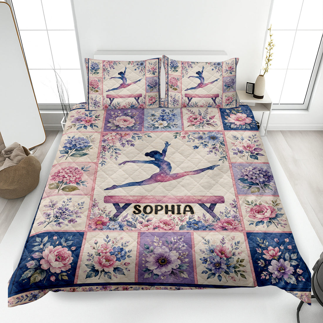Gymnastics quilt blanket displayed on a bed with floral artwork and a leaping gymnast design