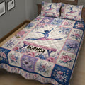 Gymnastics quilt blanket shown on a bed with a leaping gymnast and pink, purple, and blue flowers