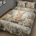 Close bedroom view of a rabbit quilt blanket covered in floral bunny scenes and soft neutral colors