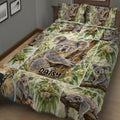 Close view of koala quilt bedding with eucalyptus leaves, tree branches, and family koala scenes