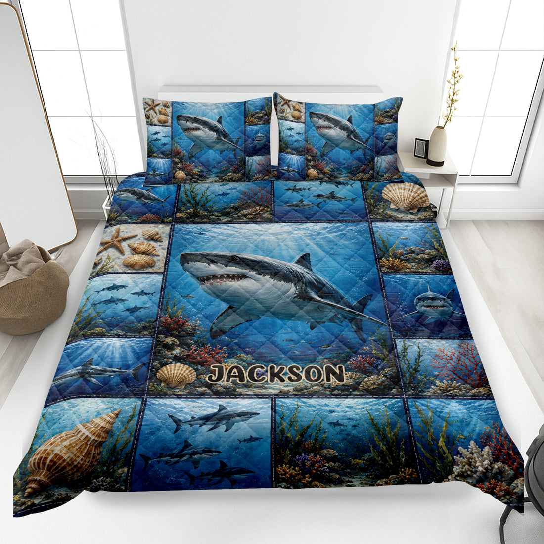 Shark quilt bedding set displayed on a bed with blue underwater artwork, coral, shells, and ocean life