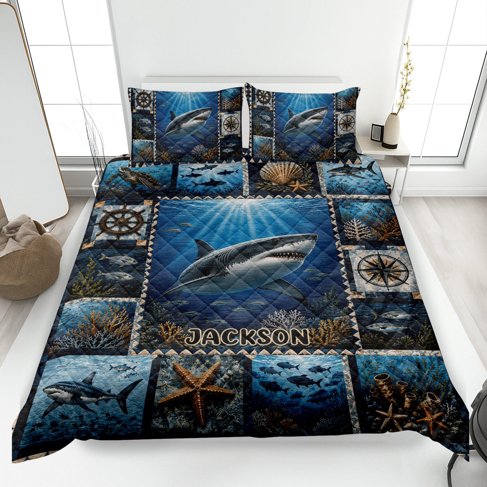 Shark quilt blanket displayed on a bed with underwater scenes, coral, fish, and nautical compass artwork