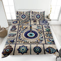 Evil Eye quilt blanket bedding set displayed on a bed with blue eye motifs, Hamsa hands, vases, and botanical accents