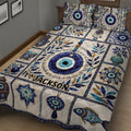 Evil Eye quilt blanket displayed in a cozy bedroom with blue protective symbols, floral accents, and decorative pottery