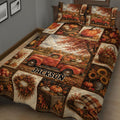 Rustic autumn quilt bedding displayed on a bed with pumpkin harvest scenes, falling leaves, and vintage truck artwork