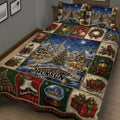Close bedroom view of Christmas quilt blanket featuring snowy village, decorated tree, lanterns, ornaments, and gifts