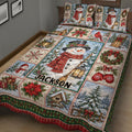 Winter Christmas quilt blanket on a bed with snowman, cardinal, sled, poinsettia, and snowy village scenes