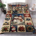 Christmas snowman quilt blanket styled on a bed in a bright bedroom with matching holiday artwork