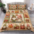 Gnome quilt blanket styled on a bedroom bed with colorful fall leaves, pumpkins, mushrooms, and harvest motifs