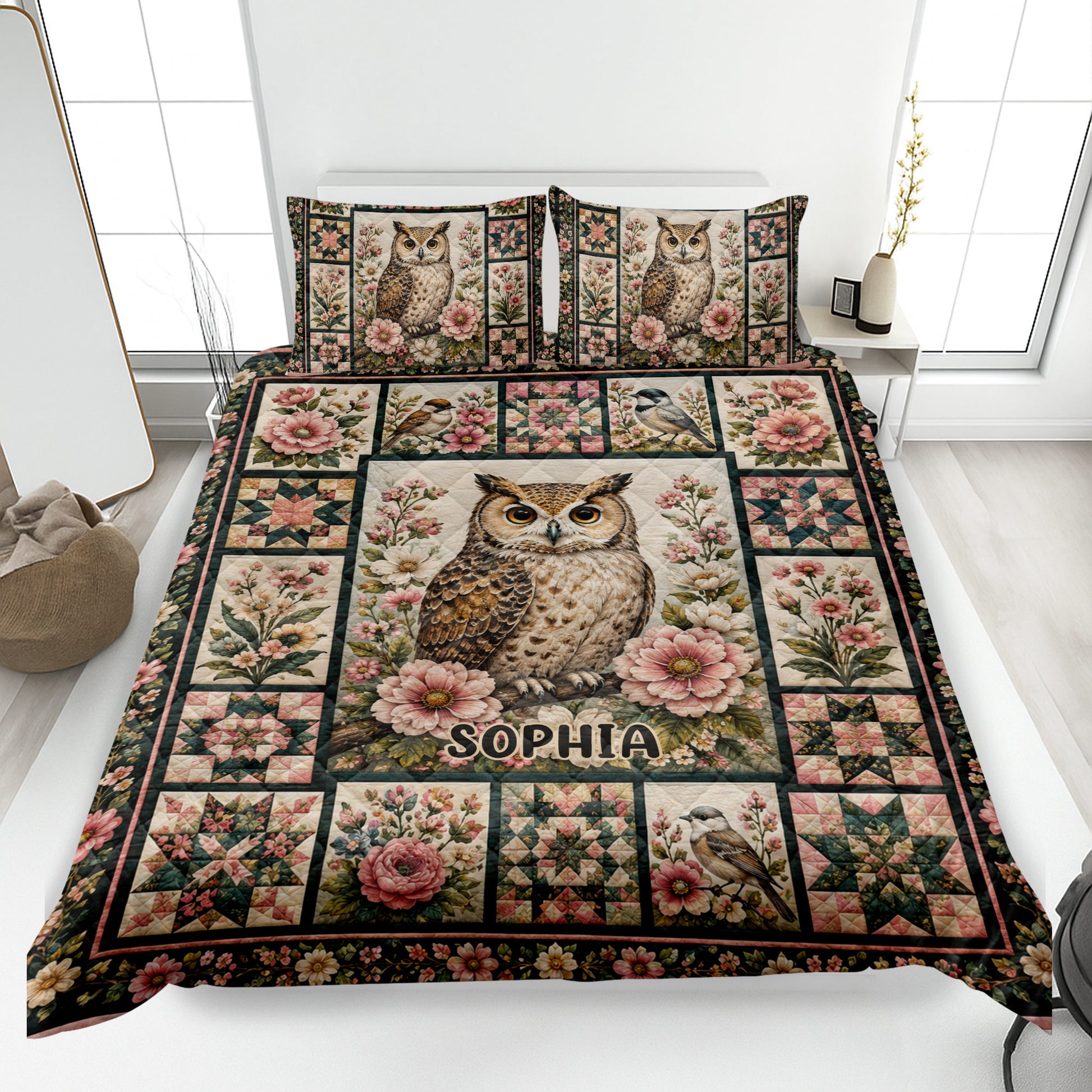 Owl quilt blanket displayed on a bed with floral artwork, birds, patchwork blocks, and a central owl motif
