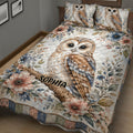 Close view of a botanical owl quilt blanket with a large perched owl and colorful flowers