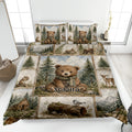 Bear quilt blanket spread across a bed with woodland scenes, pine trees, deer, and a cozy cabin