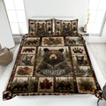 Bear quilt bedding set displayed on a bed with woodland scenes, pinecones, paw prints, and bear artwork