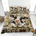 Dairy cow quilt blanket spread across a bed with daisy flowers, farmhouse panels, and matching cow artwork