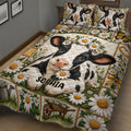 Close view of a dairy cow quilt blanket with daisies, green foliage, rustic farm panels, and floral borders