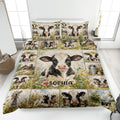 Dairy cow quilt blanket displayed on a bed with floral farm scenes and coordinated cow pillowcases