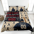 Baseball quilt blanket displayed on a bed with batter silhouettes, bats, baseballs, and navy red artwork