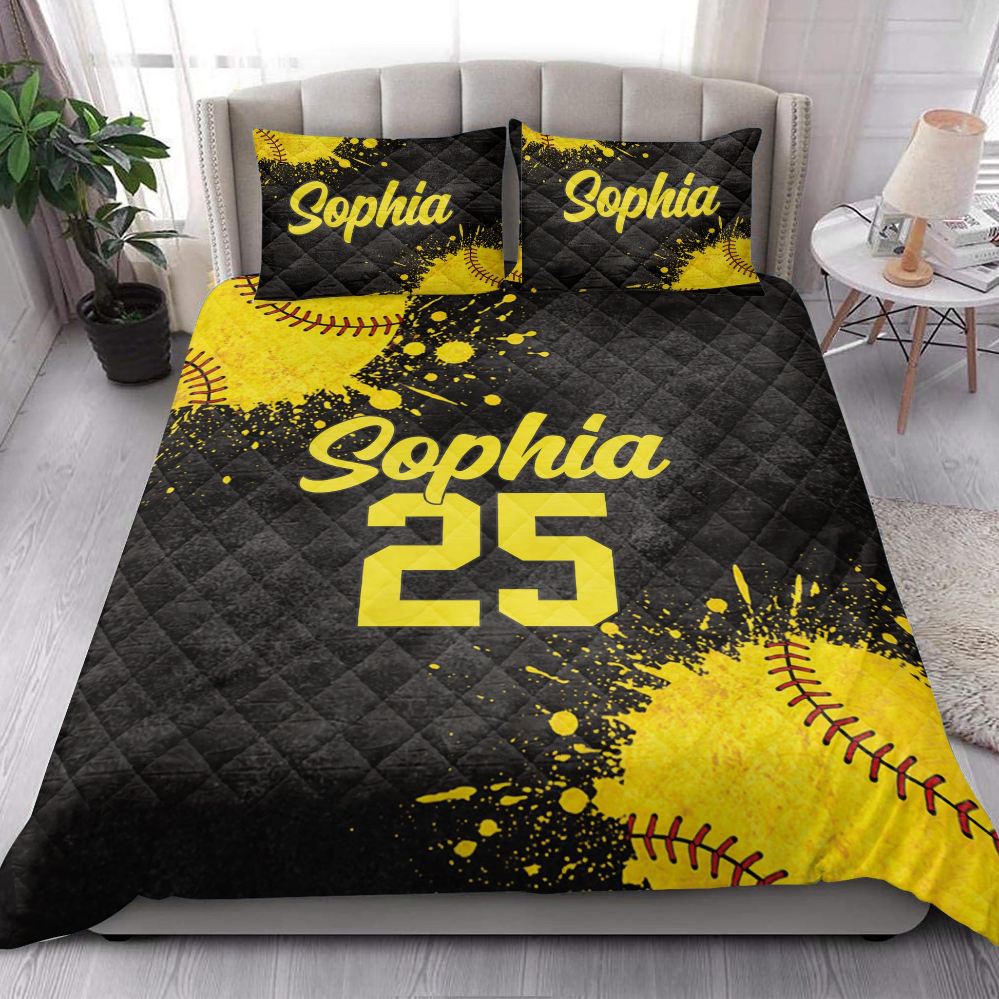 Black and yellow softball quilt blanket styled across a modern bedroom with coordinating pillows