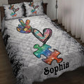 Autism quilt blanket displayed on a bed with colorful puzzle pieces, heart artwork, and a gray distressed background
