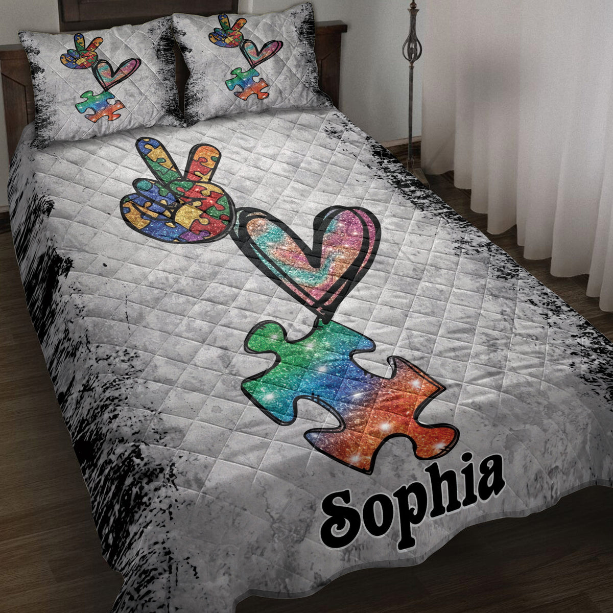 Autism quilt blanket displayed on a bed with colorful puzzle pieces, heart artwork, and a gray distressed background