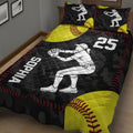 Black and yellow softball quilt blanket displayed on a bed with bold red stitching and player artwork