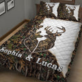 Close bedroom view of a deer quilt blanket featuring antlers, forest foliage, and camouflage artwork
