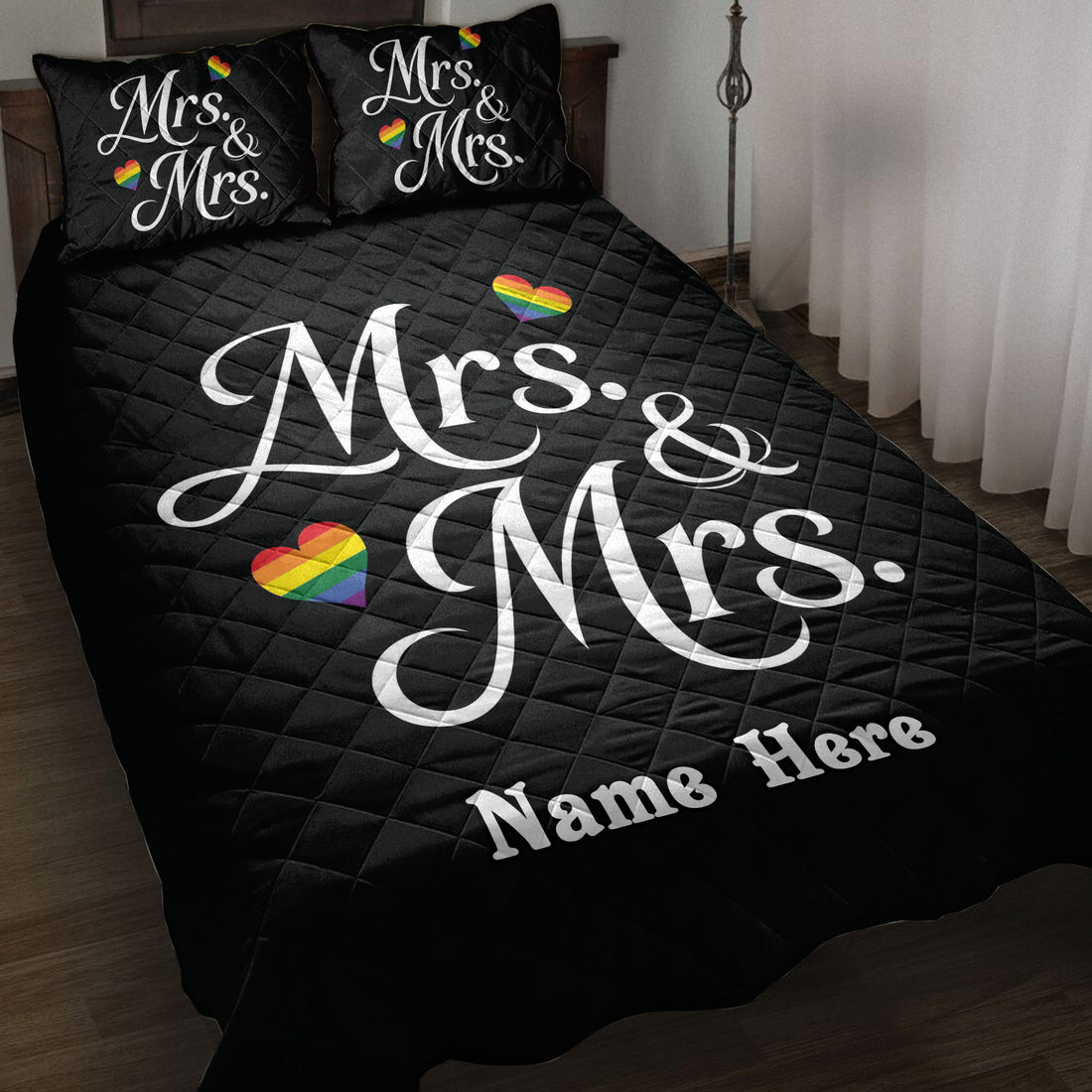Black LGBTQ+ quilt blanket displayed on a bed with white Mrs. and Mrs. design and rainbow hearts
