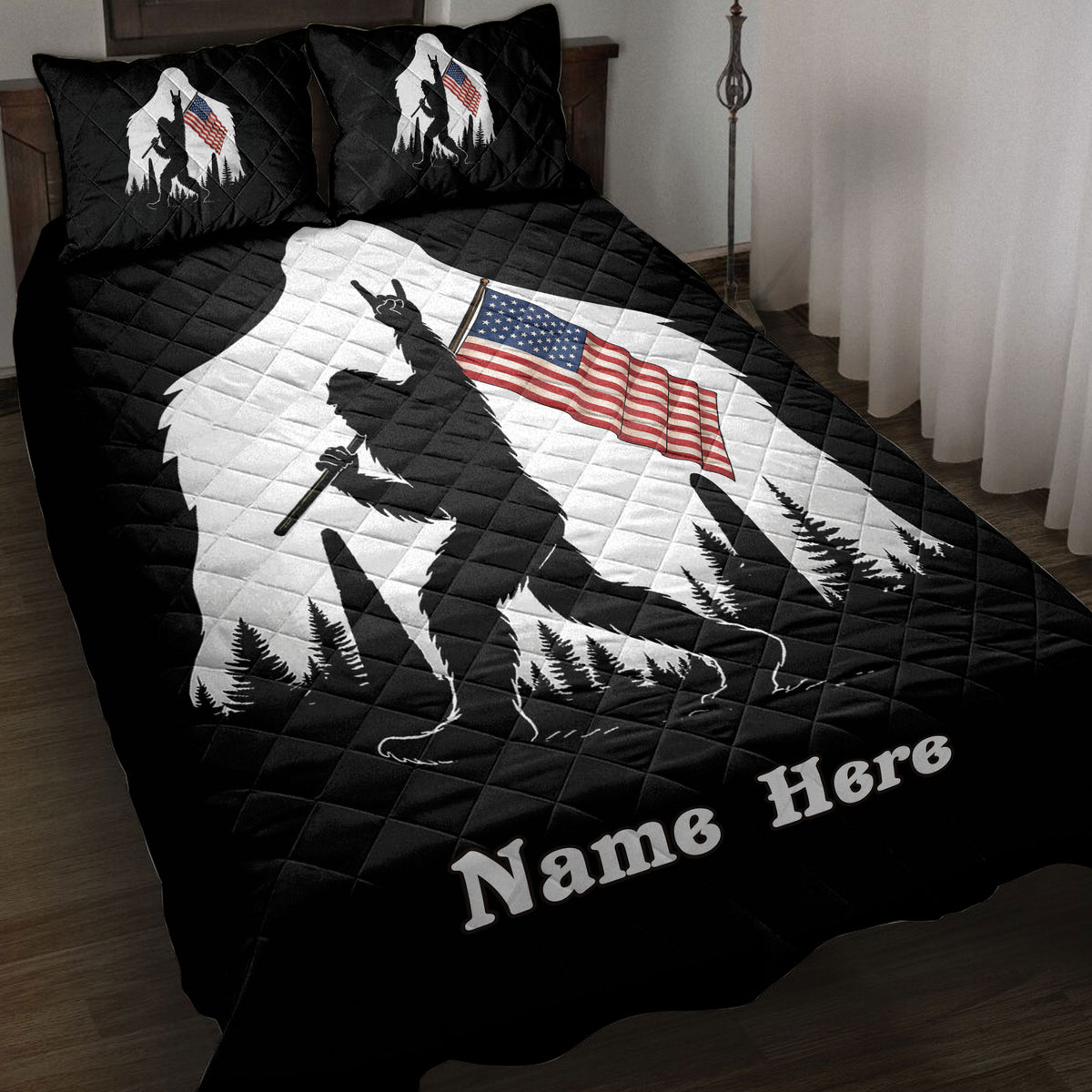 Black Bigfoot quilt blanket displayed on a bed with forest artwork and an American flag design