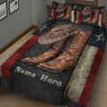 Angled view of a cowboy quilt blanket featuring brown western boots, cowboy hat, stars, and dark quilted panels