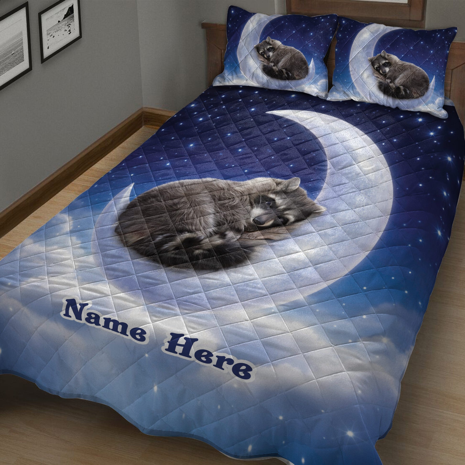 Blue raccoon quilt blanket displayed across a bed with sleeping raccoon artwork and moonlit stars