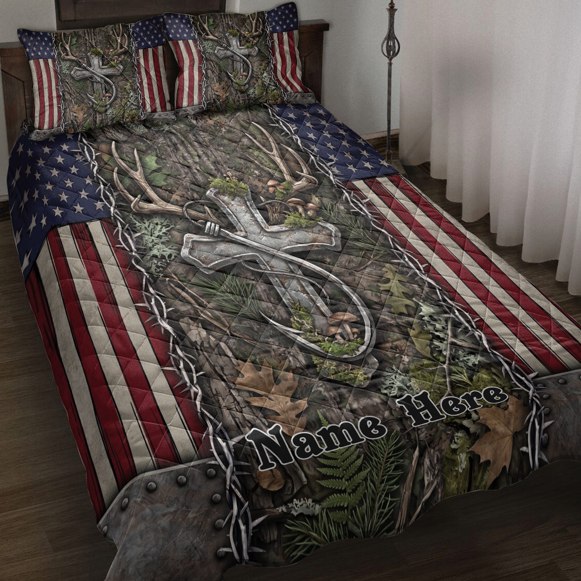 Hunting quilt blanket displayed on a bed with deer antlers, camouflage foliage, and American flag accents