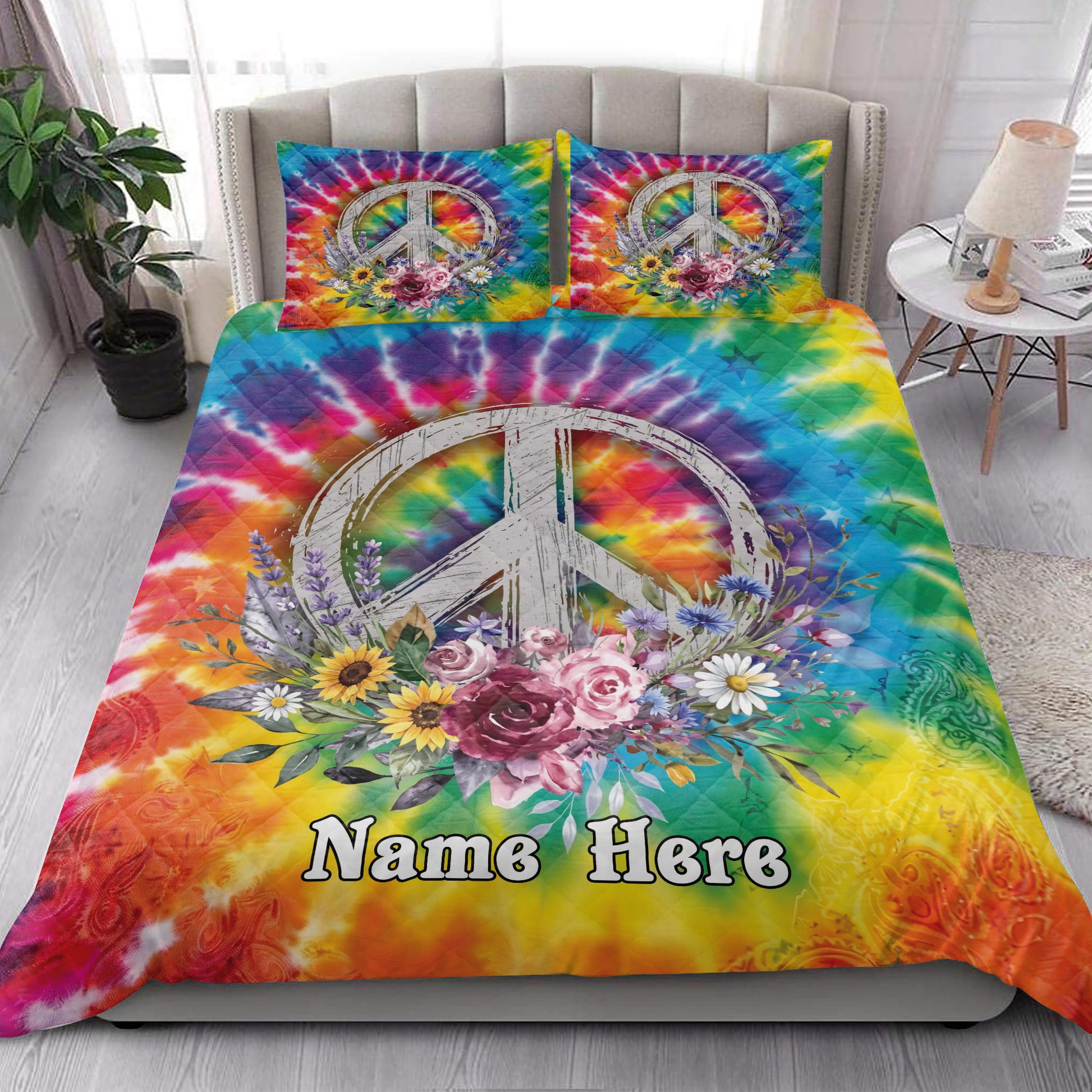 Bohemian hippie quilt blanket styled on a bed with bright tie-dye colors, peace symbol, and flowers
