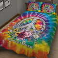 Colorful hippie quilt bedding set displayed in a bedroom with floral peace symbol artwork