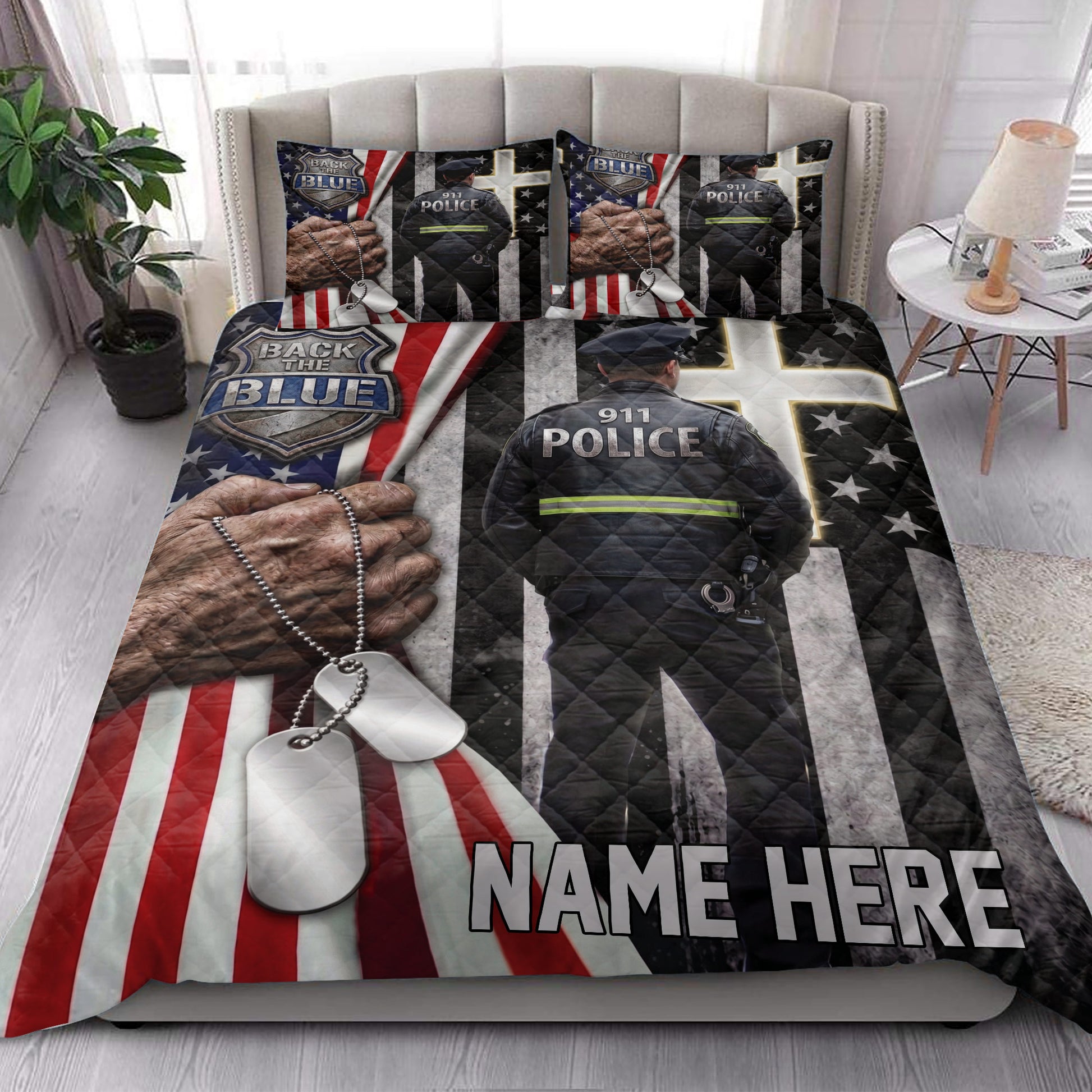 Police quilt bedding styled in a bright bedroom with officer artwork, badge graphics, dog tags, and patriotic flag details