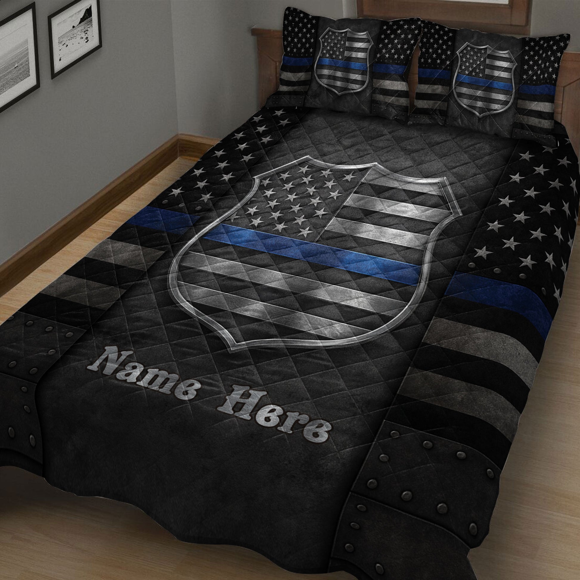 Close bedroom view of a police quilt blanket featuring large badge artwork, stars, and a blue line