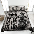 Motocross quilt blanket displayed on a bed with dirt bike riders, tire tracks, and bold black and white racing artwork