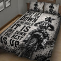Motocross quilt bedding displayed on a wooden bed with dirt bike racing artwork and tire-track border details