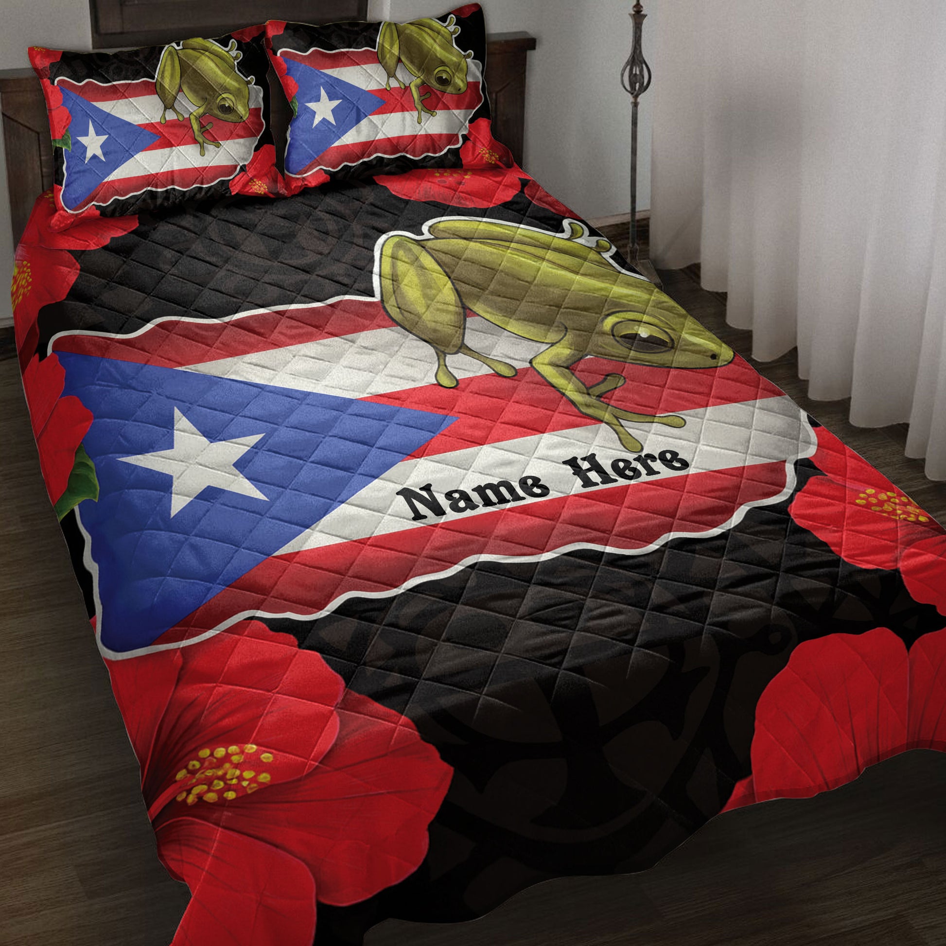 Puerto Rico quilt blanket featuring a coqui frog, flag design, red hibiscus flowers, and bold black accents on a bed