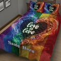 Close bedroom view of a rainbow LGBT quilt blanket with flowing heart artwork and a colorful Pride design