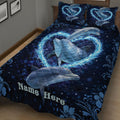 Close angled view of a dark blue dolphin quilt with glowing water rings and floral accents