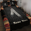 American Native-inspired quilt blanket on a bed with feather artwork and colorful geometric border patterns