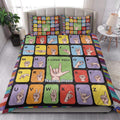 Sign language alphabet quilt blanket styled on a bedroom bed with colorful hand sign blocks