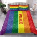 Rainbow Pride quilt bedding styled across a modern bed with matching striped pillows