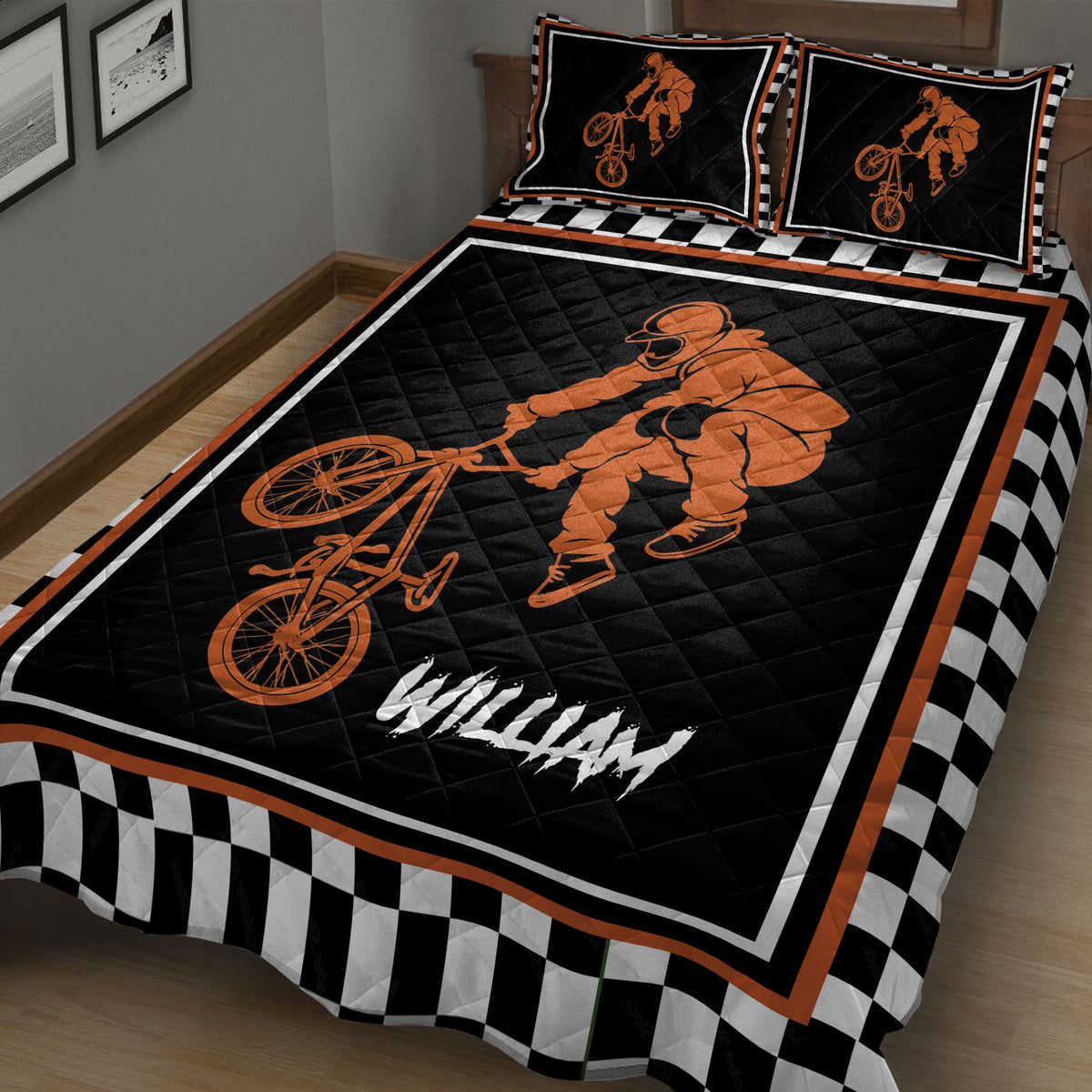 Close bedroom view of BMX quilt blanket with orange bicycle rider artwork and checkerboard border